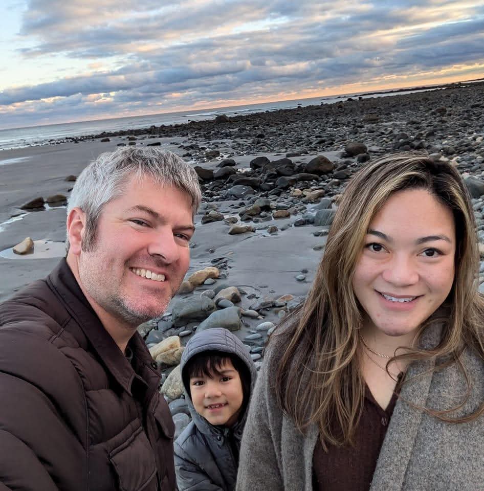 Jenn, Tristan, and Noah on a rocky beach at sunset